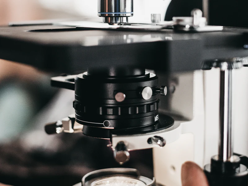 Persona ajustando el enfoque de un microscopio